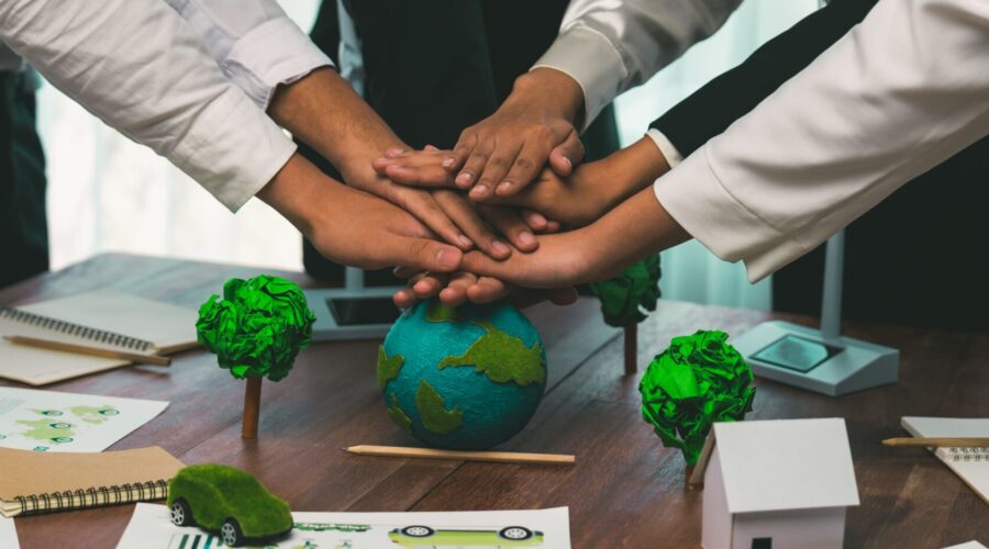 Group of business people put hand stack showing synergy of corporate cooperation on environmental protection to save Earth. Environmental awareness and eco unity concept. Trailblazing
